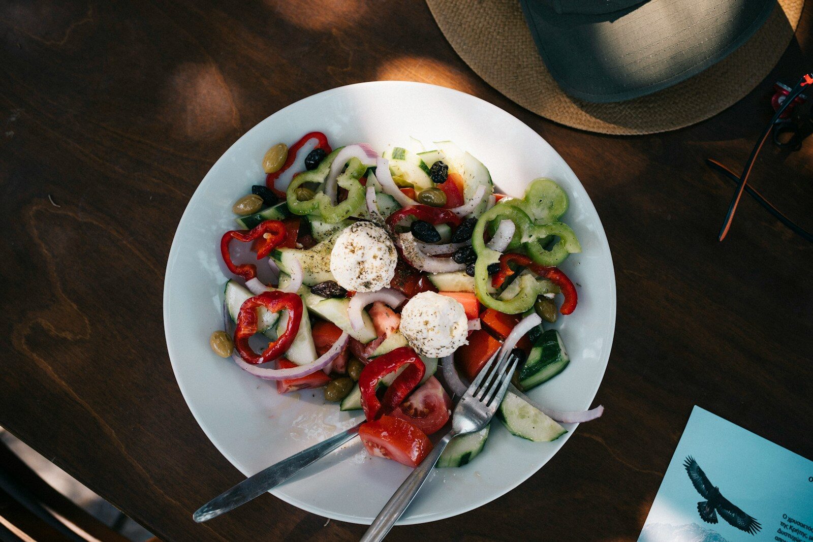 a white plate topped with a salad and a fork