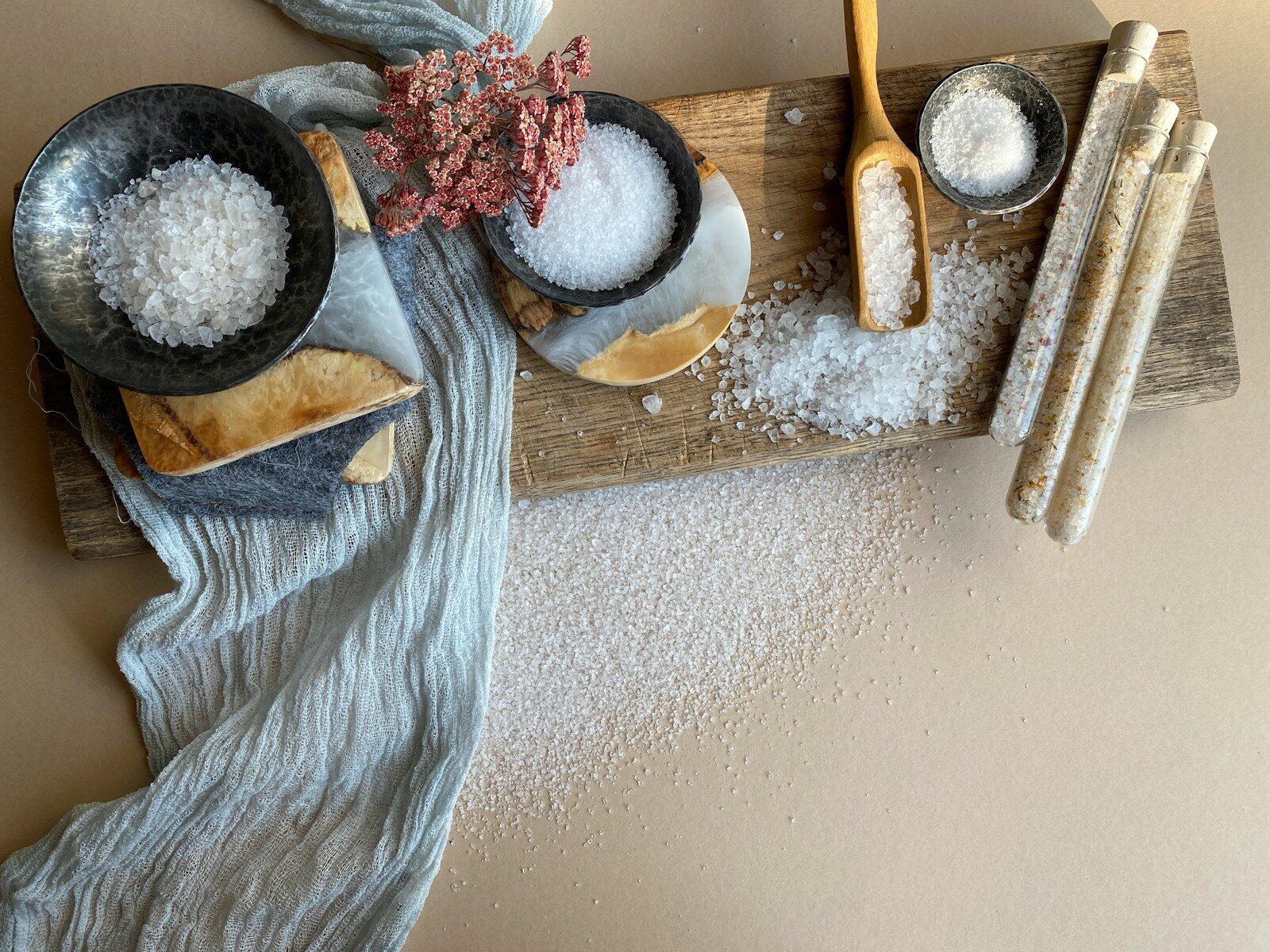 a person's hand holding a piece of wood with a pile of objects on it