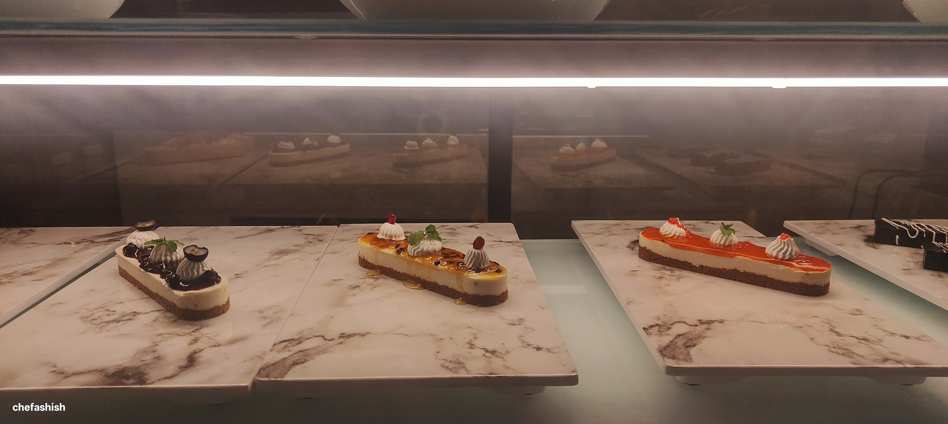 Entremets arranged in a chilled dessert display case
