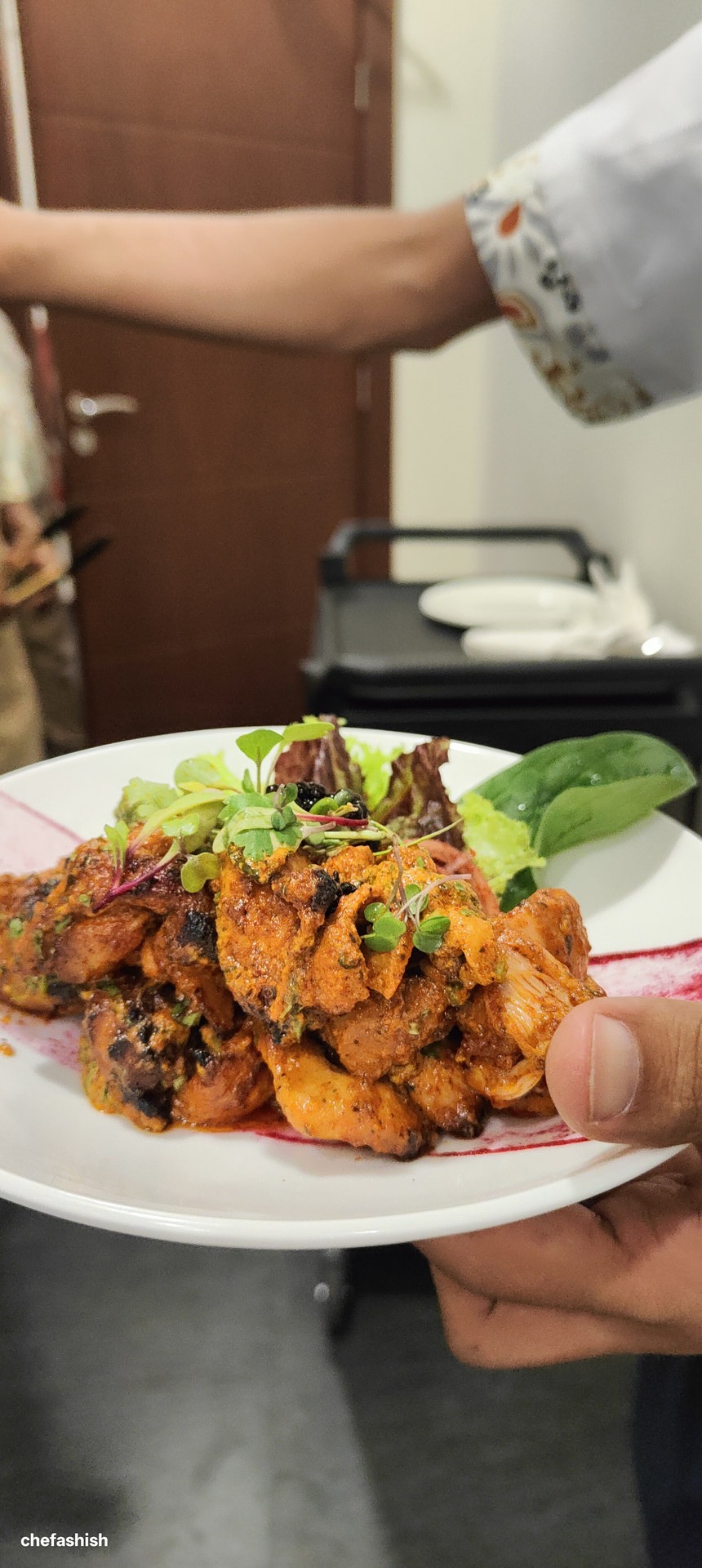 A plated spiced chicken dish leaving the pass