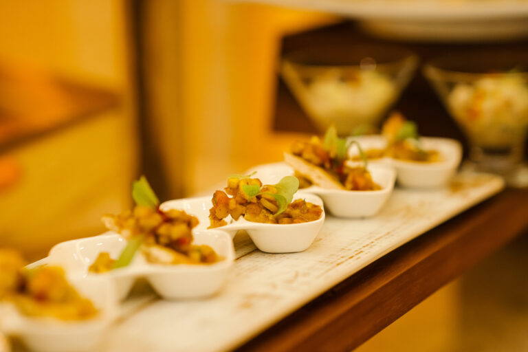 Canape spoons lined up on a wooden board