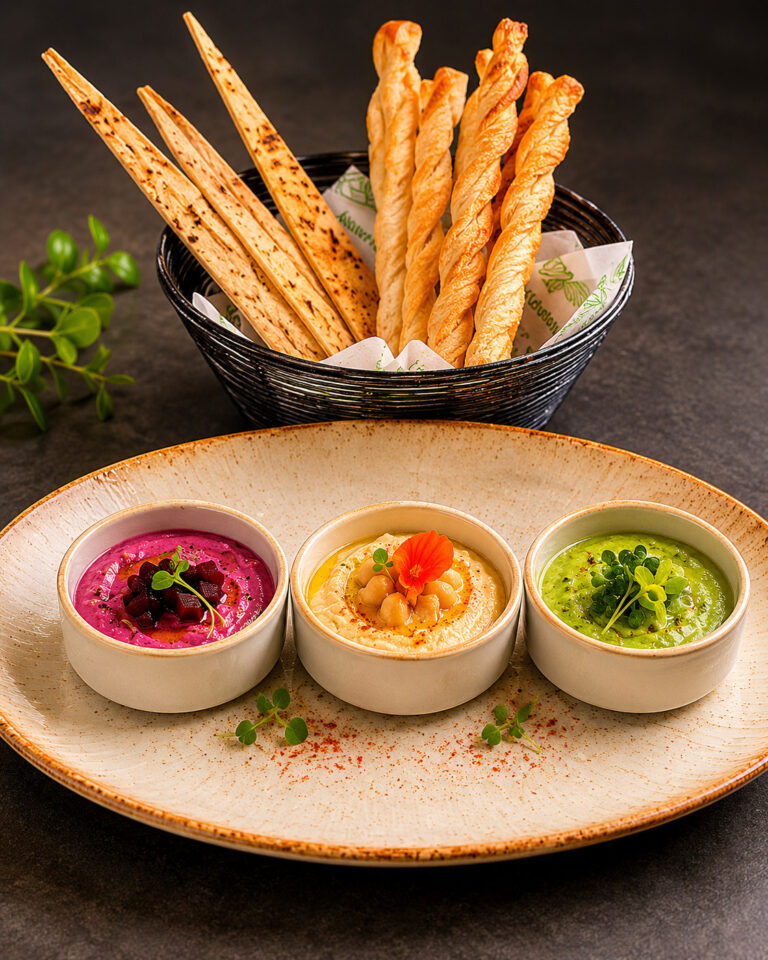 A trio of hummus dips with breadsticks