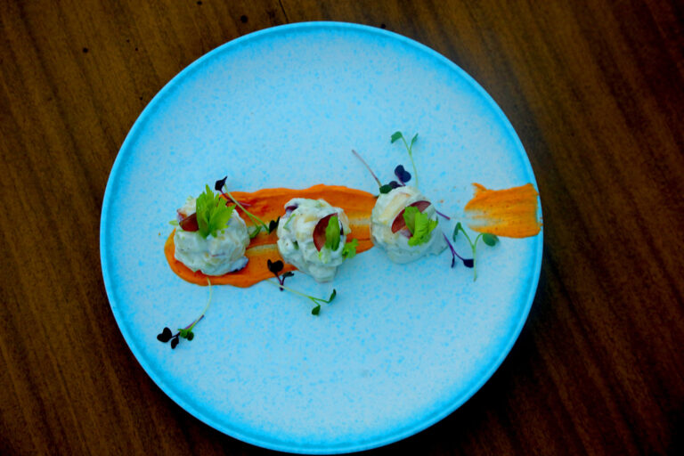 Salad quenelles plated on blue