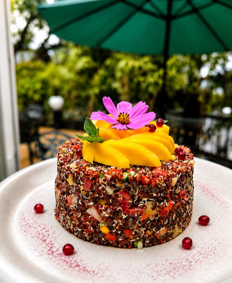 Quinoa and mango tower salad plated in a garden setting